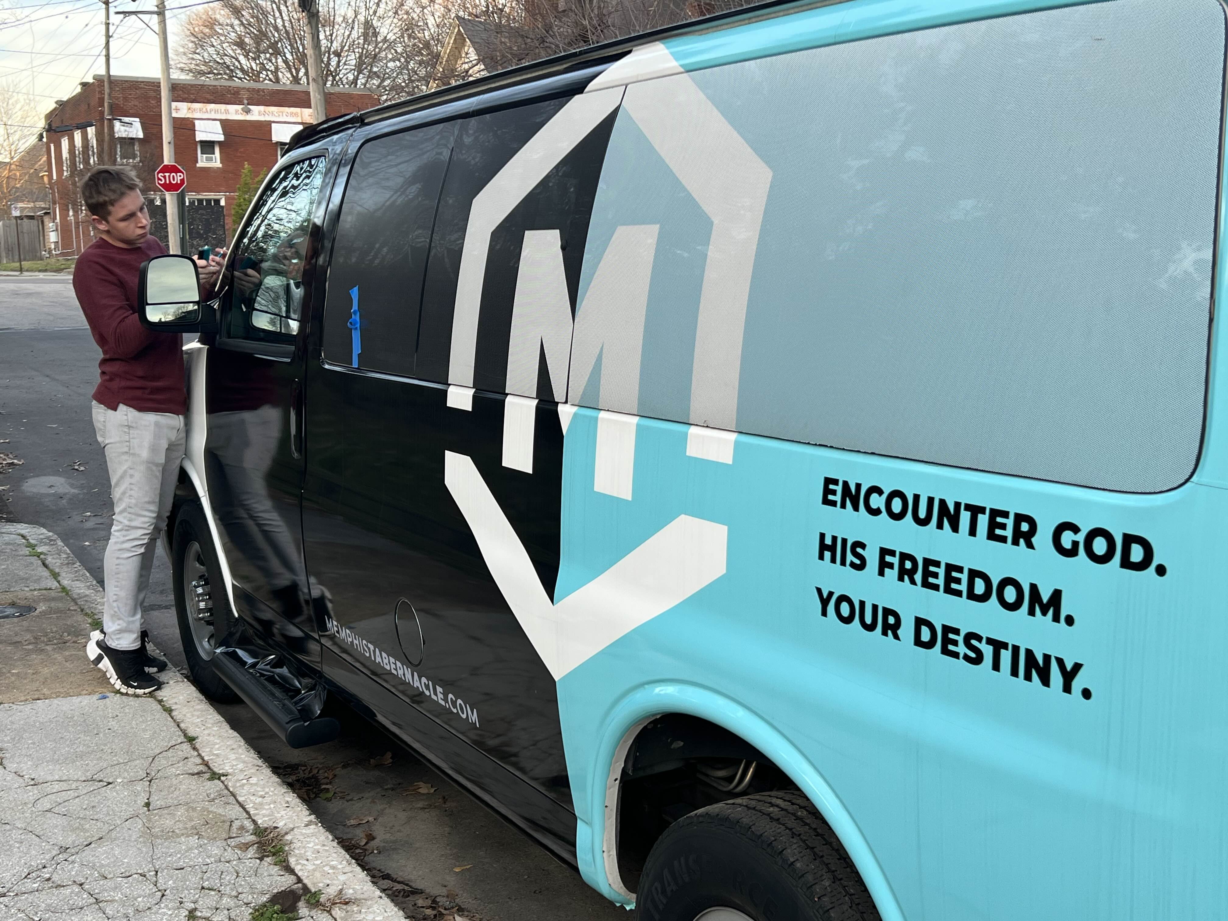 Commercial van with a full wrap being installed on-site